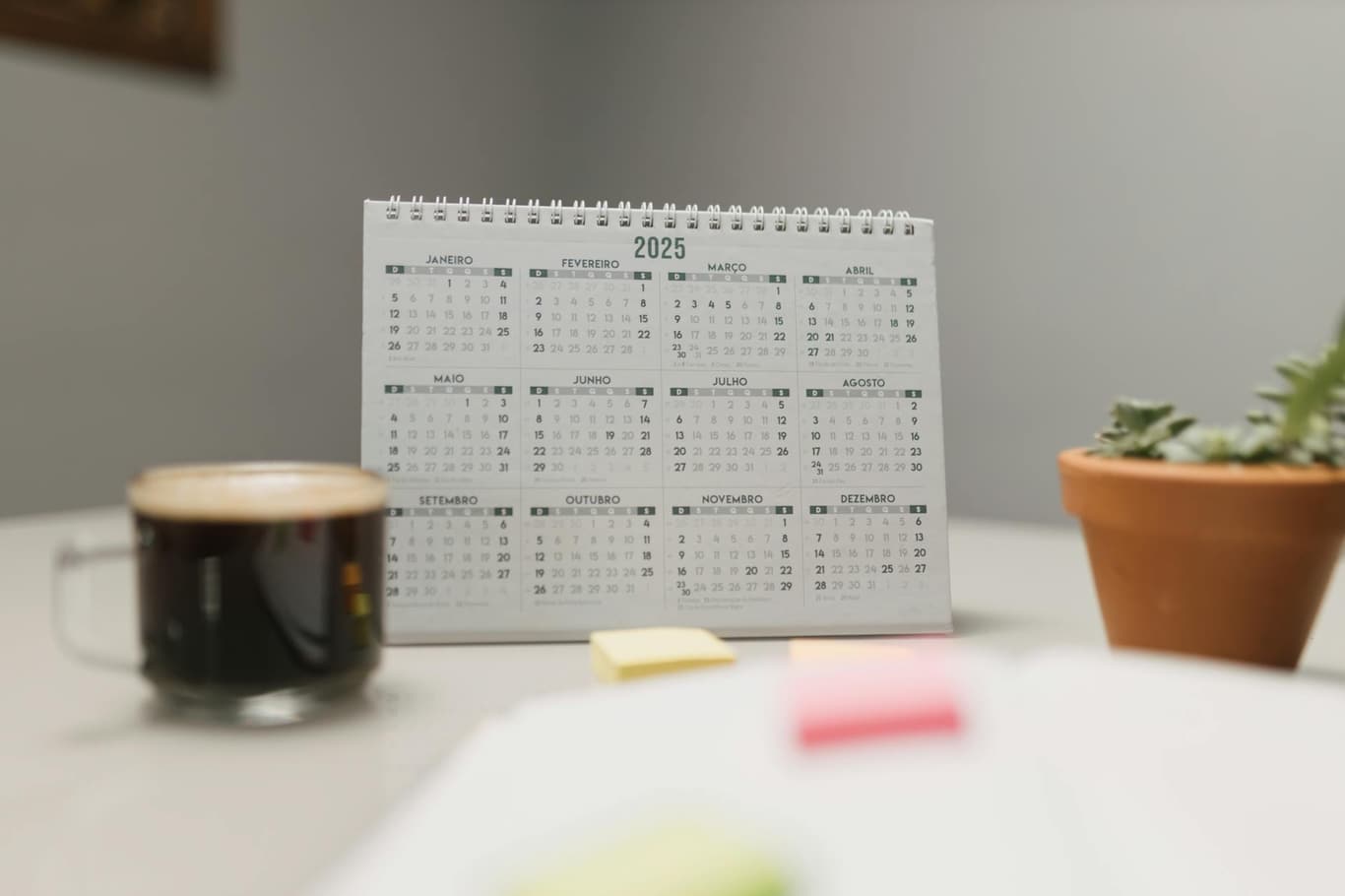 Sanduhr und Kalender auf einem Schreibtisch als Symbol für Zeitpläne und Planung bei der Kontoeröffnung