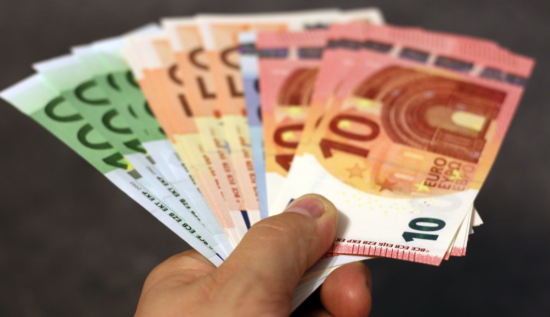 Various currencies and banknotes on a table—multi-currency IBANs