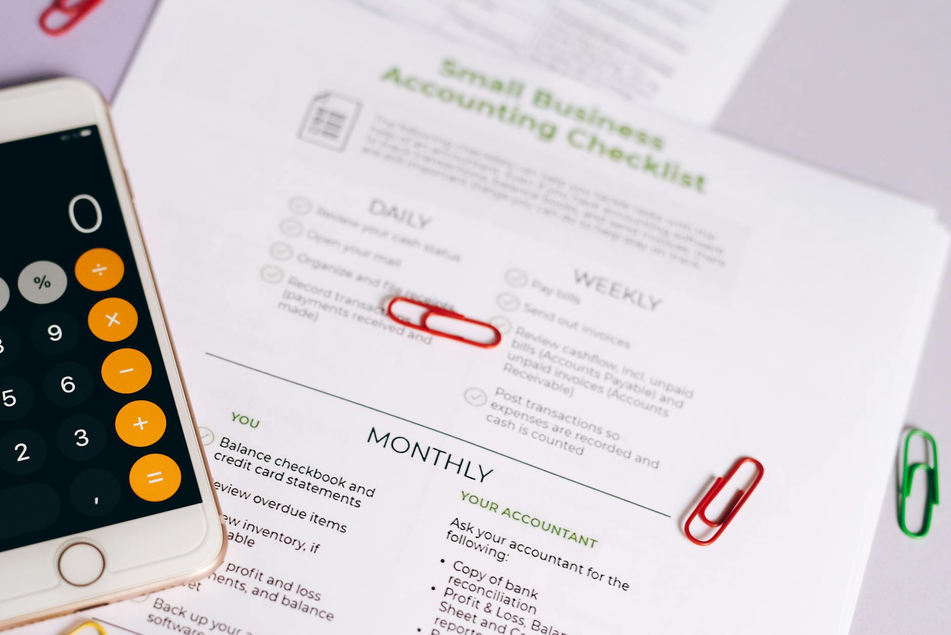 Compliance documentation and business verification checklist on desk with laptop