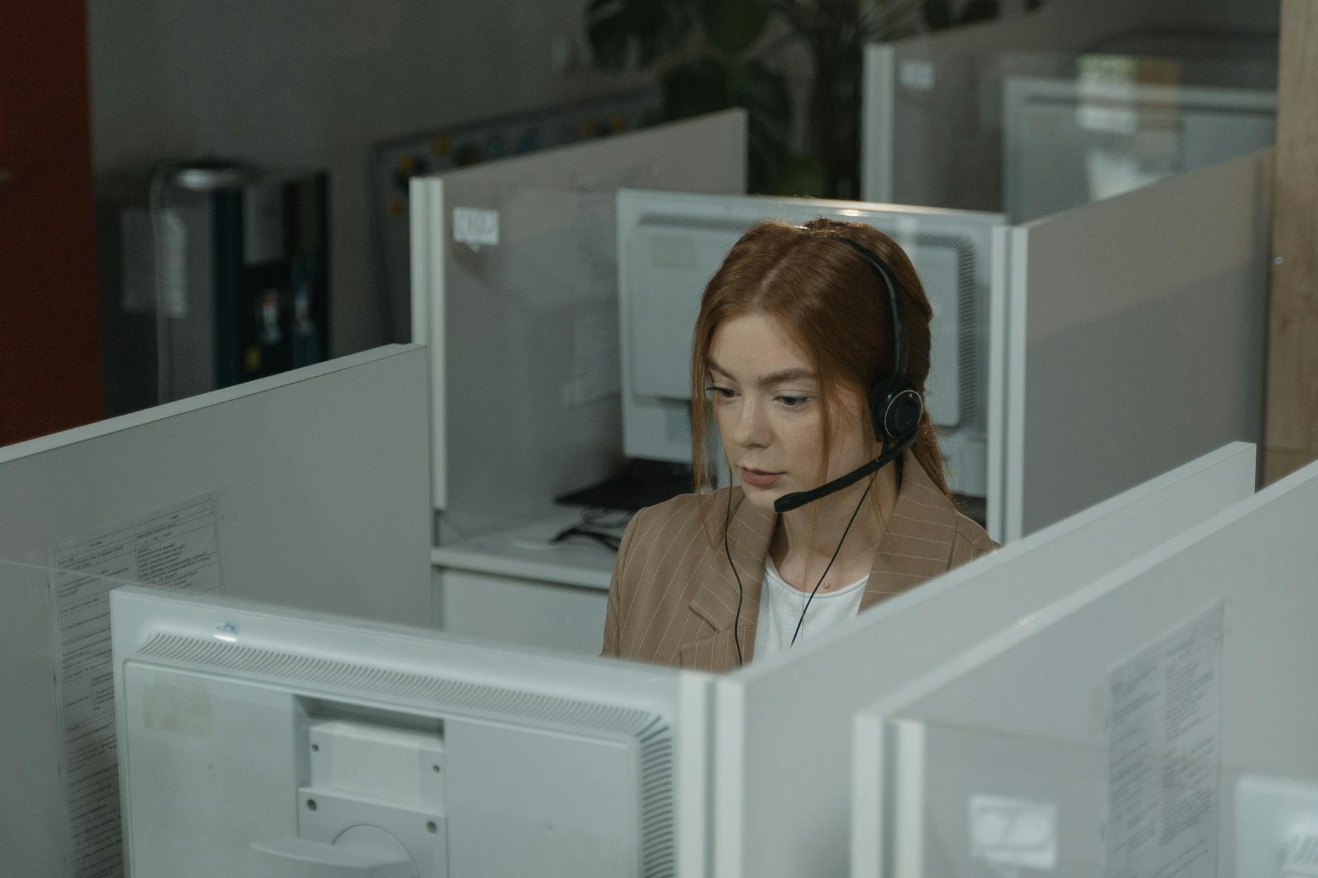 Dedicated account manager providing support to client via headset at modern workspace