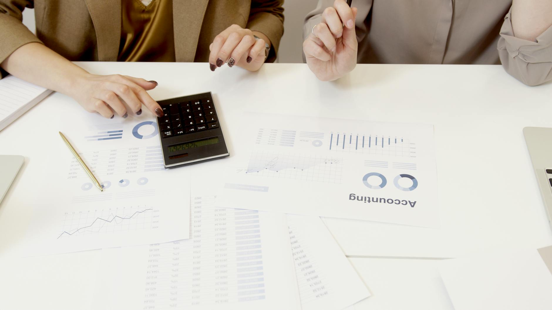 Accountant working with financial spreadsheets and calculator at desk